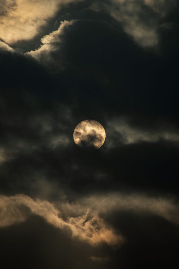 full moon peeking through a night sky